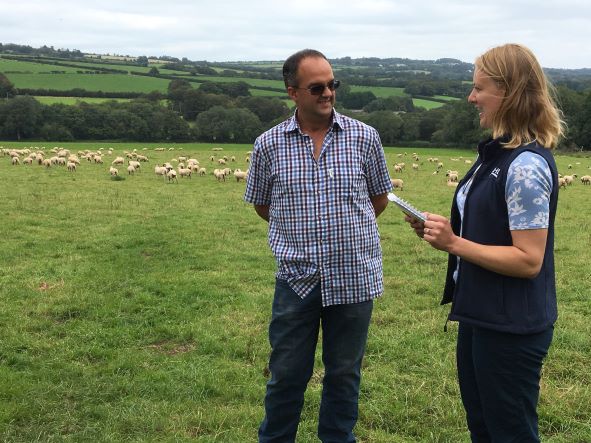 Adrian Coombe and Sarah Hurford in a field with Adrian's sheep
